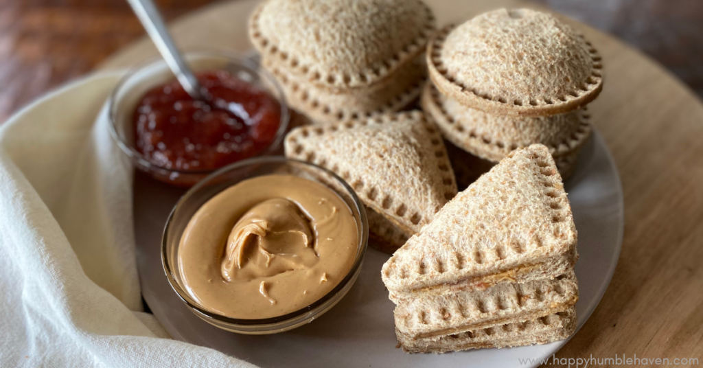 Homemade PB&J Uncrustables on plate with bowls of peanut butter and jelly.