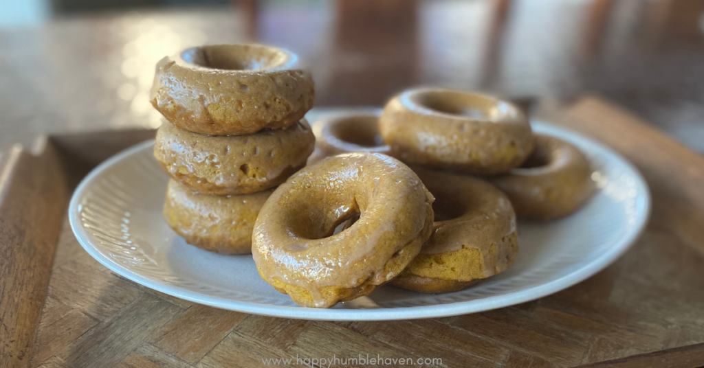 Simple Baked Pumpkin Donuts stacked on platter on wooden tray.