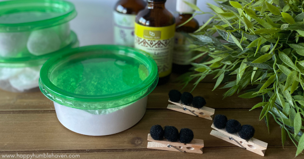Image of 3 homemade car air fresheners sitting on a wooden table with a plant next to them